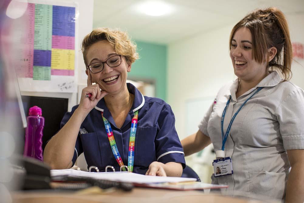 Two nurses sharing a joke while at work