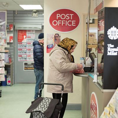 An elderly lady making payment in a post office